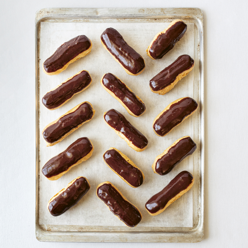 A tray of chocolate-covered eclairs arranged neatly.